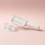 Illustration of a white ice roller next to ice cubes on a blush backdrop
